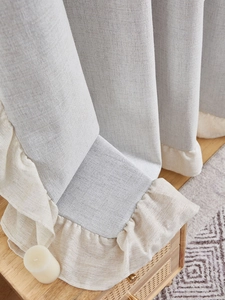 Detail of light gray linen curtain with beige ruffle trim and thick fabric texture