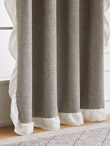 Close-up of grey linen curtain featuring elegant white ruffled edges and fabric texture