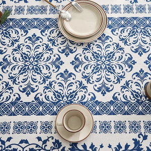 Blue and white porcelain style tablecloth with floral patterns in a top-down dining setup