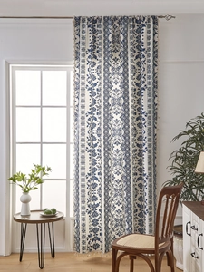 Detail of blue floral print curtains with tassel fringe and textured linen fabric