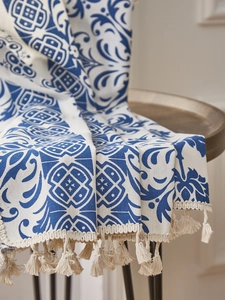 Close-up of blue and white porcelain pattern fabric with handmade beige tassels