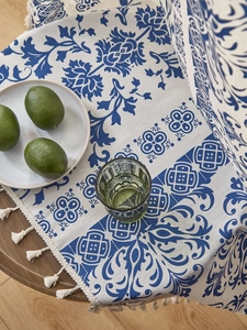 Close-up of blue floral cotton linen tablecloth with tassels in a dining setting
