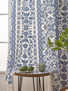 Detail of blue chinoiserie floral curtains with white handmade tassels and bohemian fringe