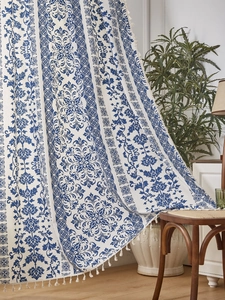 Detailed blue floral porcelain pattern on fabric with white fringe tassel edges