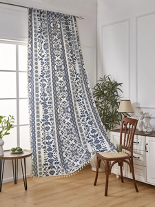 Detail of blue damascus floral pattern on cotton linen curtain with cream tassels