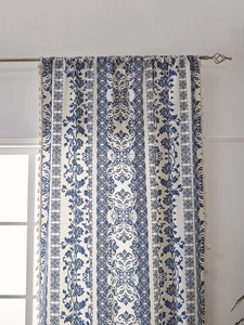 Detail of blue floral porcelain patterns with tassel trim on white cotton curtains