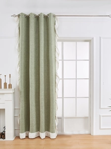 Dettaglio della tenda in lino grigio-verde con bordi a balze bianchi e anelli in metallo