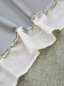 Dettaglio del bordo a balze grigio e beige della tenda in lino spesso con cuciture