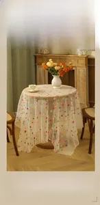 Detail of floral lace embroidery on vintage cream mesh tablecloth for home decor