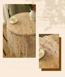 Close-up of multicolor floral embroidery on translucent mesh lace tablecloth