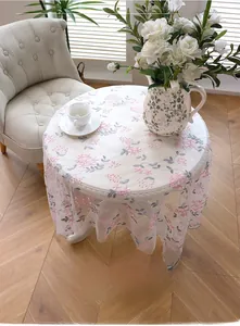 Detailed embroidery of pink floral patterns on ivory lace tablecloth for round tables