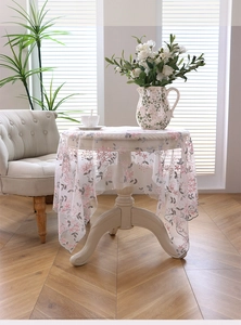 Detail of floral lace embroidery on sheer mesh tablecloth with scalloped edges