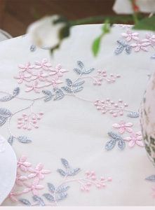 Detail of floral embroidery on white translucent lace fabric for table decor