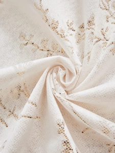 Dettaglio macro della tenda in pizzo con ricamo floreale e morbido drappeggio elegante