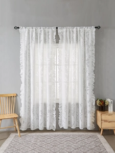 Détail d'un rideau blanc semi-transparent avec bordure à volants et motifs de feuilles