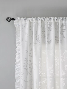 Détail du rideau en dentelle blanche avec imprimé feuilles grises et bord à volants