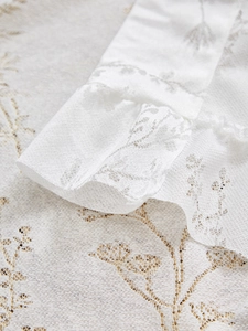 Détail de broderie en dentelle blanche sur tissu de rideau avec texture florale