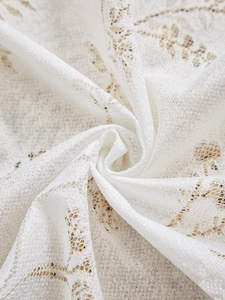 Gros plan sur un tissu en dentelle blanche avec broderie florale et texture en maille fine