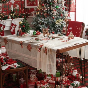 Kerstkant tafellaken met rode kerstster borduursels op een houten eettafel binnen