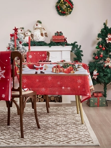 Detail view of festive red Christmas tablecloth and chair covers with Santa Claus patterns