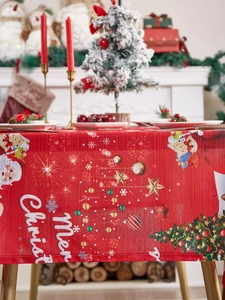 Detailed weave texture of red Christmas tablecloth with Santa and reindeer patterns