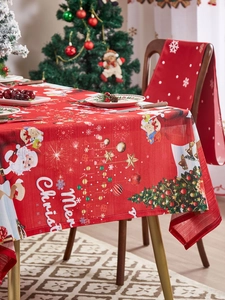 Detail of red Christmas tablecloth with Santa, trees, and Merry Christmas print