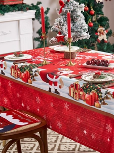 Close-up of festive red Christmas tablecloth with Santa Claus and snowflake prints