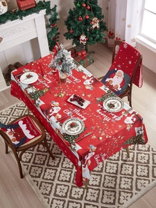 Detail of red Christmas tablecloth and chair covers featuring Santa Claus and tree patterns