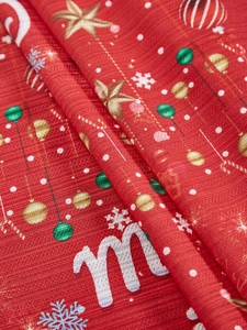 Close-up of red Christmas fabric with gold stars and snowflake patterns for festive decor