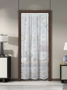 Detail of white French lace door curtain with vintage floral patterns and wavy edges