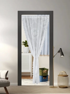 Detail of white semi-transparent lace door curtain with floral embroidery and scalloped edges