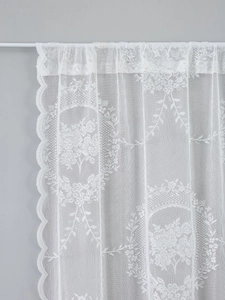 Detailed close-up of white French floral lace curtain with elegant scalloped edges