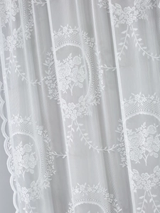 Close-up of French vintage white lace door curtain with floral rose embroidery patterns