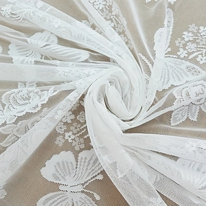 Detail von weißem Spitzenstoff mit Schmetterlings- und Rosenmustern für Vorhänge