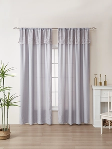 Detail of light purple curtain with elegant white lace valance and metal curtain rod