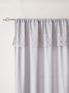 Detail of light purple sheer curtain with delicate white lace embroidery on rod pocket