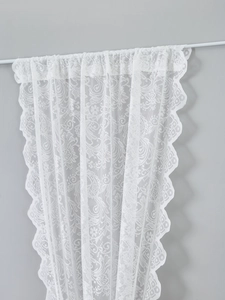 Detail of white French lace curtain with delicate floral embroidery and scalloped edges