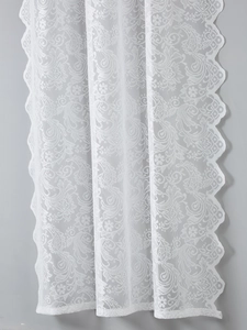 Close-up of white French lace fabric with intricate floral patterns and scalloped edges