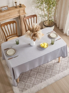 Detailed texture of lilac woven tablecloth with pom-pom fringe in a Nordic home setting