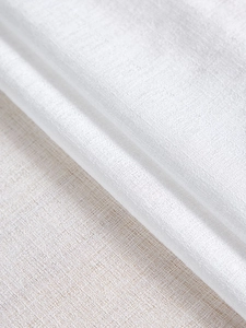 Close-up detail of white linen fabric tablecloth with soft texture and elegant woven pattern