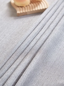 Macro view of light grey textured fabric tablecloth with natural woven linen pattern