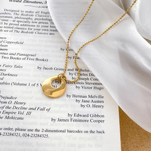Collier avec pendentif ovale plaqué or 18 carats sur satin blanc et fond de livre vintage