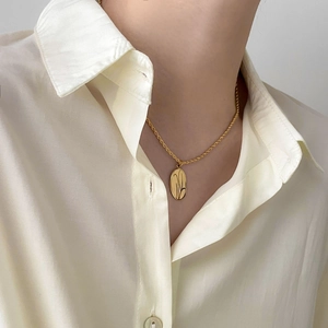 Collier minimaliste en or avec chaîne torsadée et pendentif ovale au cou