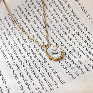 Détail macro du pendentif rond en nacre avec zircon sur une chaîne en or 18 carats
