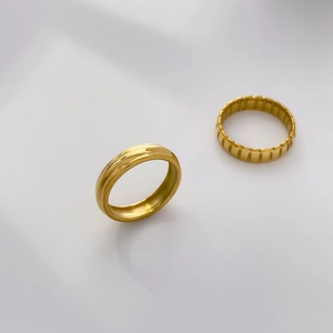 Detailed view of layered 18K gold plated stainless steel rings with vertical grooves