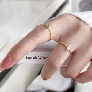 Set of two gold titanium steel rings with square and marquise zirconia on a twisted band