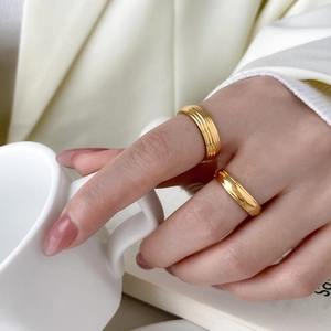 Layered 18K gold plated titanium rings with grooved texture in a lifestyle shot