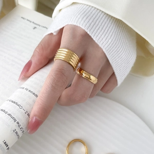 Close-up of stacked 18K gold-plated titanium steel rings with textured layered design