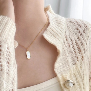 Détail du collier plaqué or 18 carats avec pendentif rectangulaire en nacre sur modèle