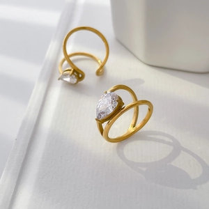 Détail de la bague dorée double couche avec un zircon en forme de poire